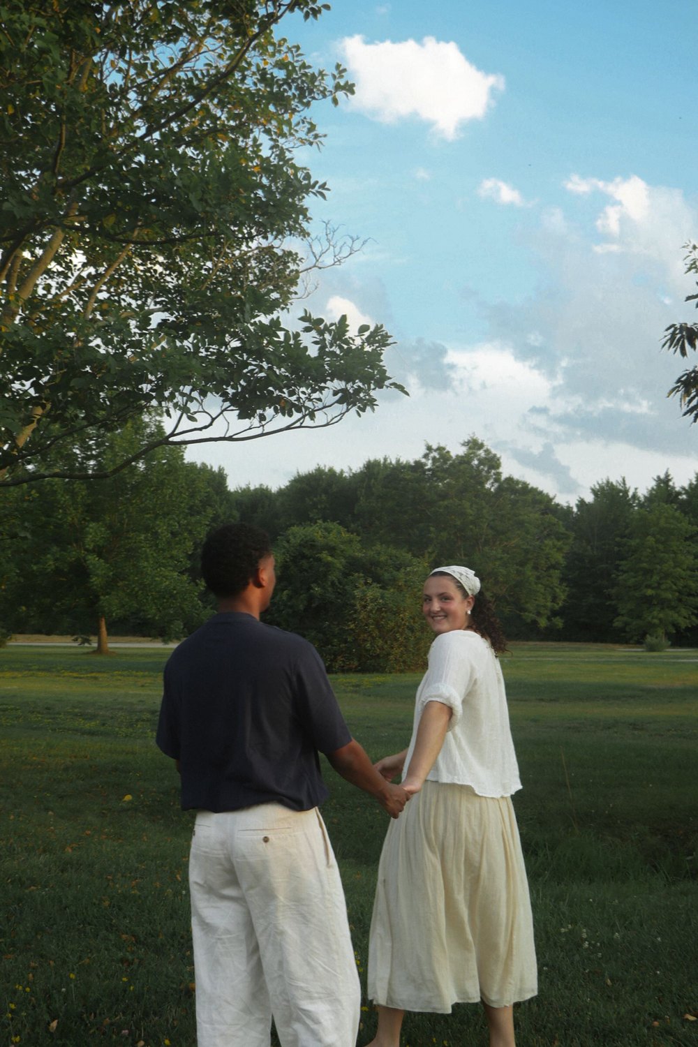 Couple holding hands on a green lawn