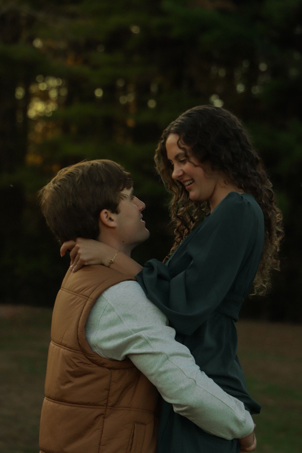 Couple embracing beneath trees